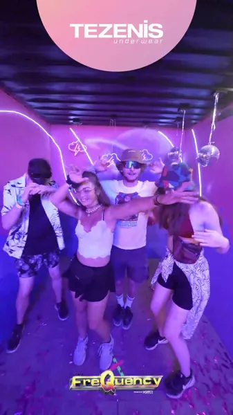 Gäste im Neonlicht der Tezenis-Glambot-Station am Frequency